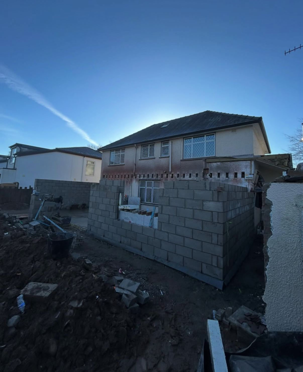 New blockwork extension walls built up at the rear of a home before roofing and openings are completed.
