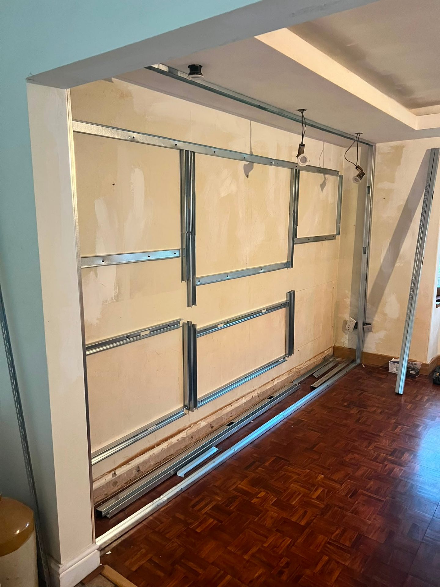 Steel track and stud framing for a custom living room media wall installation.