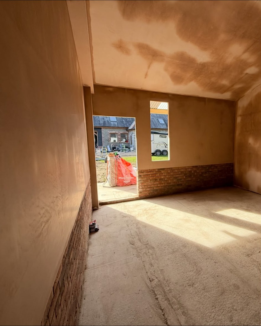 Freshly plastered interior extension walls and ceiling with brown float finish above exposed brickwork by LEWZ in South Wales